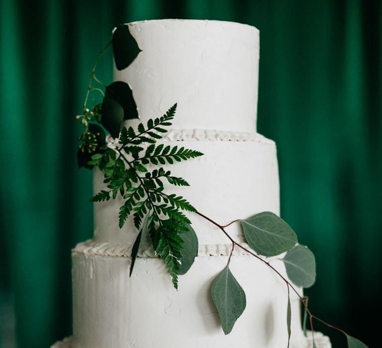 Homemade white wedding cake with foliage decor