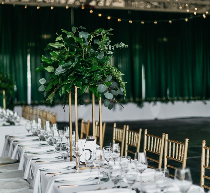 gold chairs and tall foliage centrepiece