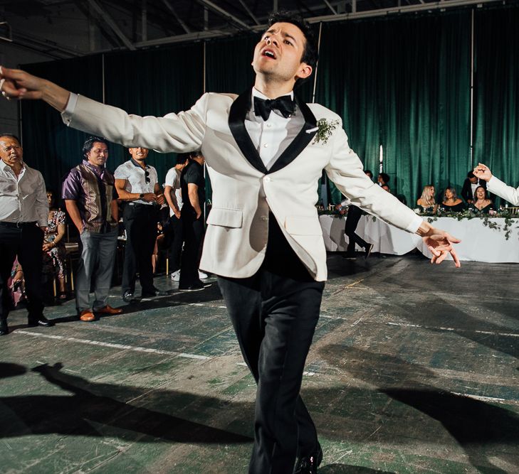 Groom and groom dancing in matching white tuxedo dinner jackets