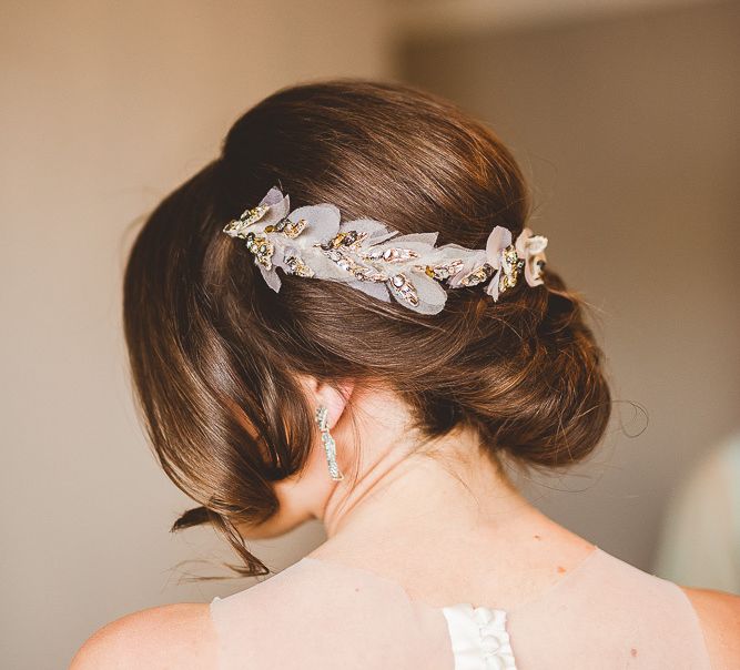 Low bun wedding hair with bridal accessory