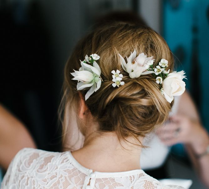 Pinned bridal up do with fresh flower in her hair