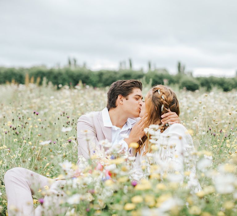 Bride and groom kissing in a summer meadow