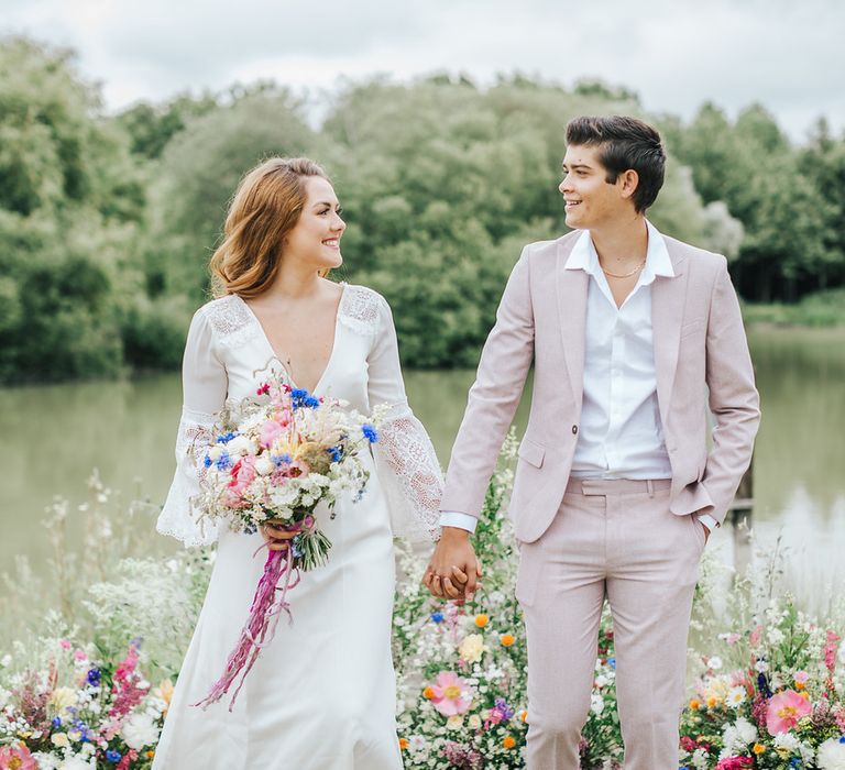 Bride and groom holding hands at the outdoor wedding ceremony - wedding ideas for summer