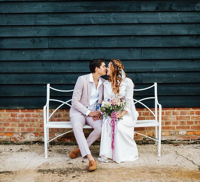 Bride and groom kissing on a bench