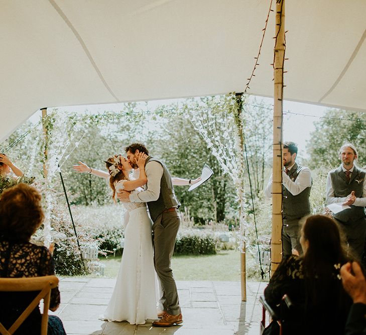 Bride and Groom Kissing at Wedding Ceremony Under a Stretch Tent