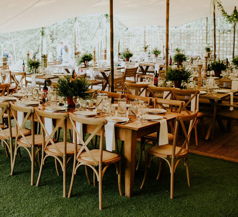 Stretch Tent Wedding Reception with Wooden Tables and Greenery Decor