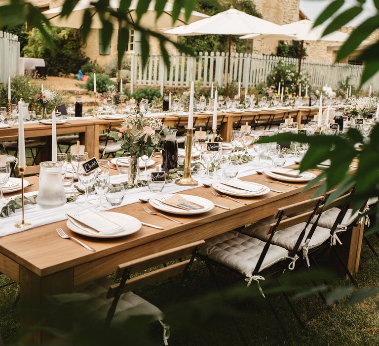 Long Wooden Reception Tables Decorated with Table Runner, Floral Centrepieces and Flowers