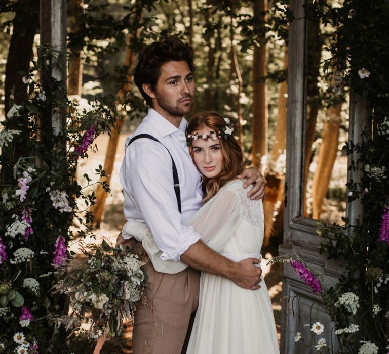 Boho bride and groom portrait embracing in front of wooden doors