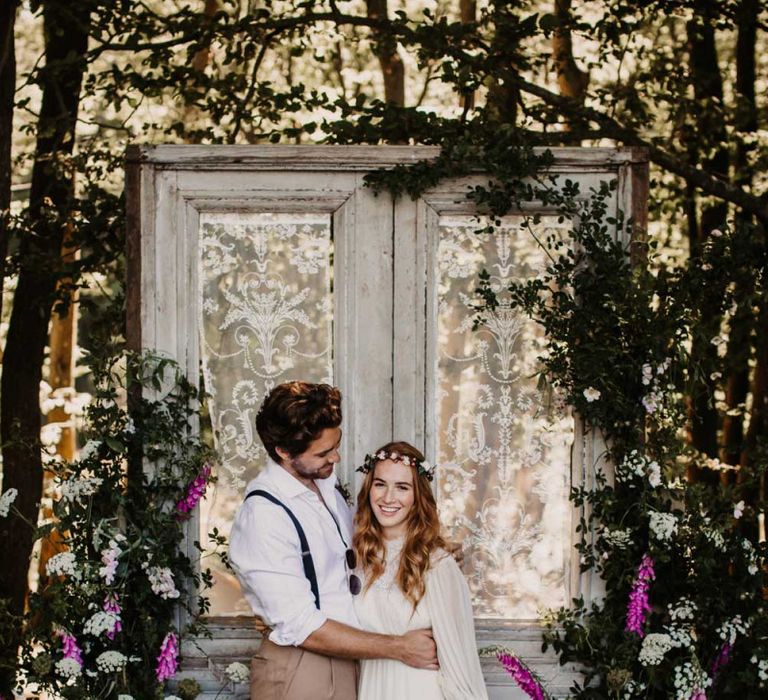 Bride and groom portrait at Wickerwood Farm with door and wildflower backdrop