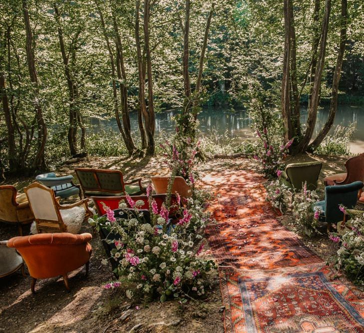 Outdoor wedding ceremony at Wickerwood Farm with rugs, vintage furniture and wildflowers