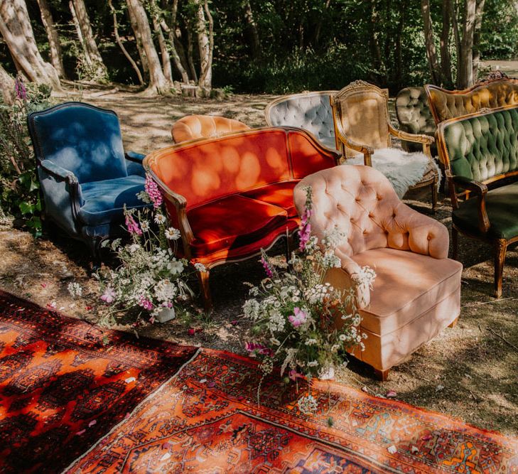 Vintage chairs and sofas at outdoor woodland wedding ceremony