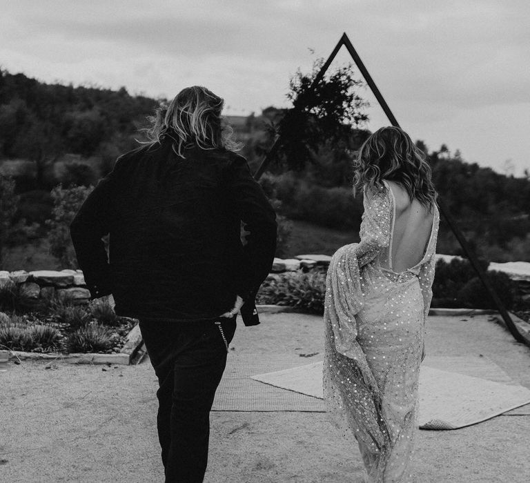 Black &amp; White Portrait of Bride in Backless Shimmering Wedding Dress and Groom in black Suit