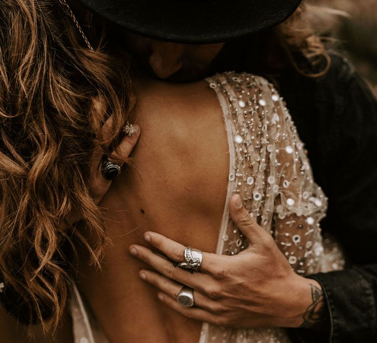 Intimate Moment Between Bride and Groom with Groom Hugging His Bride in Backless Shimmering Gold Wedding Dress