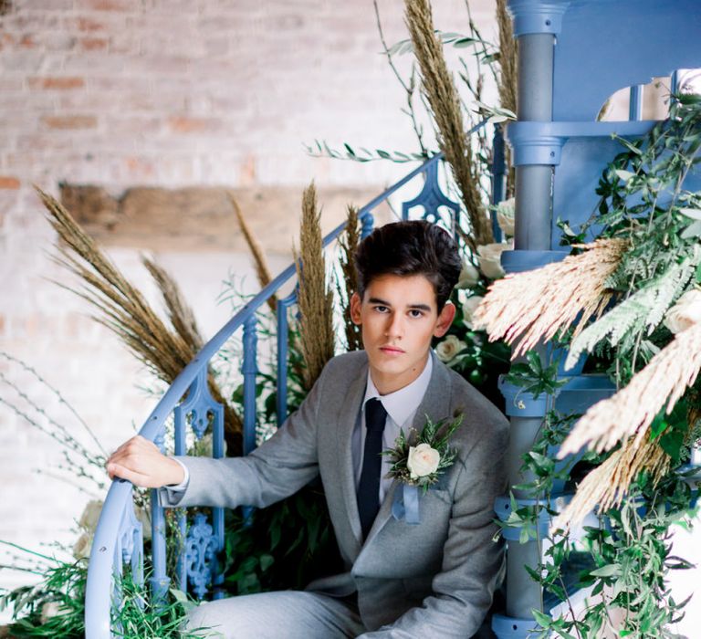 Groom in Grey Suit Sitting on Blue Spiral Staircase