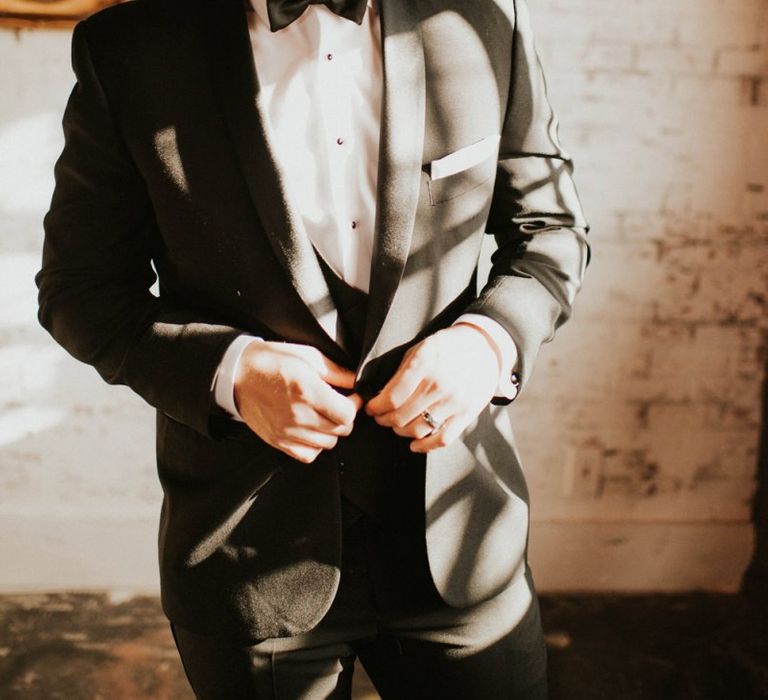 Groom in black tie suit