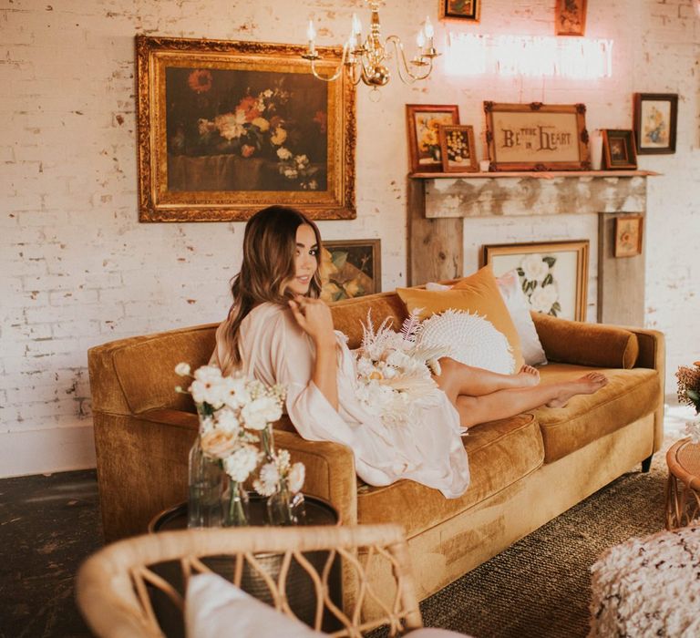 Bride on wedding morning resting on a couch