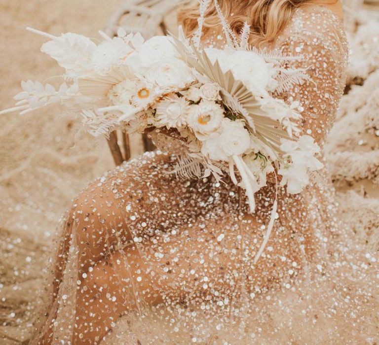 Boho wedding bouquet with white flowers, dried grasses and palm leaves