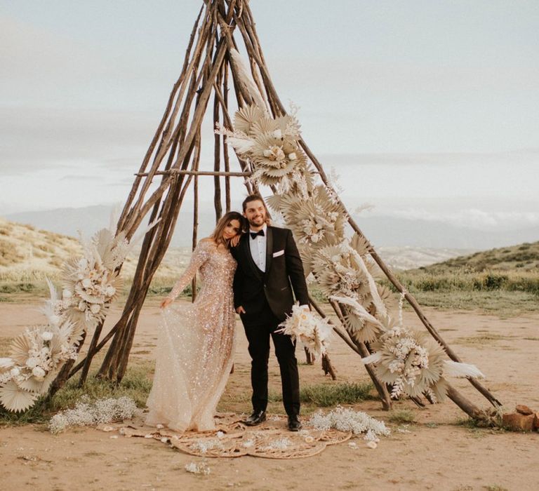 Naked tipi decorated with dried palm leaves and grasses