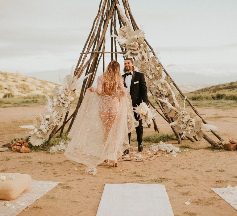 Boho bride in sparkly wedding dress swinging the skirt