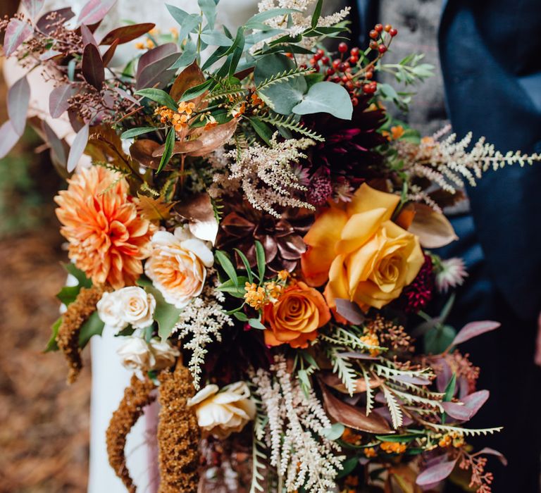 Orange, Red And Brown Autumnal Wedding Bouquet // Balloon And Floral Arch For Wedding Ceremony At Patrick's Barn Woodland Industrial Wedding Venue With Grazing Board Style Food Images By Brigitte &amp; Thierry Photography