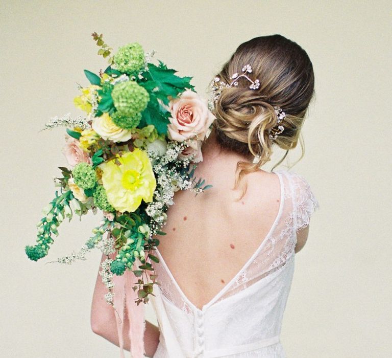 Bride in Naomi Neoh Wedding Dress Holding a Yellow and Green Bridal Bouquet Over Her Shoulder