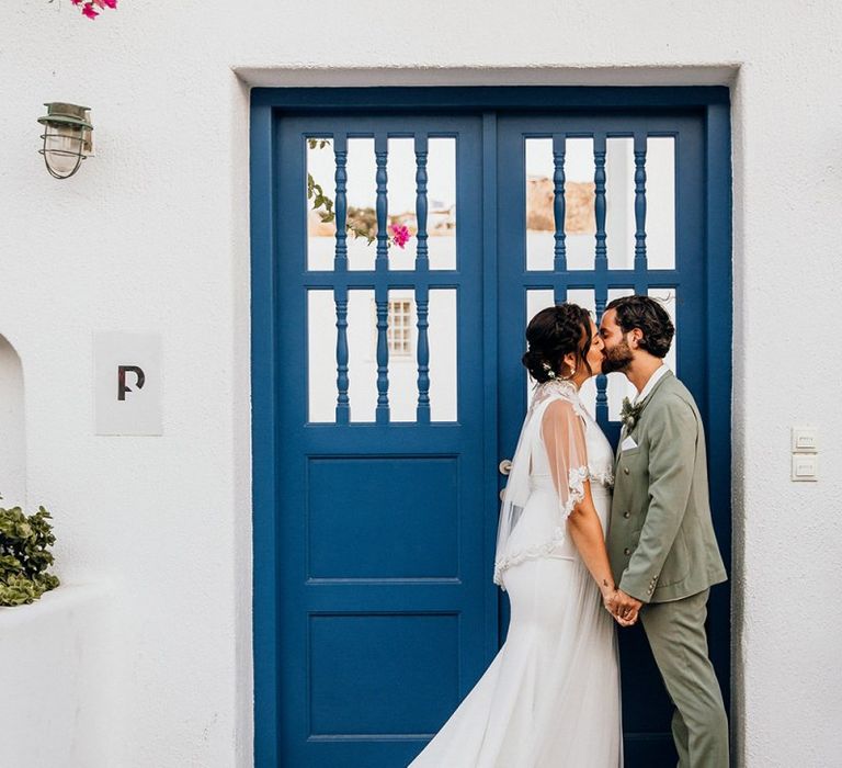 Bride in wedding capelet kisses new husband