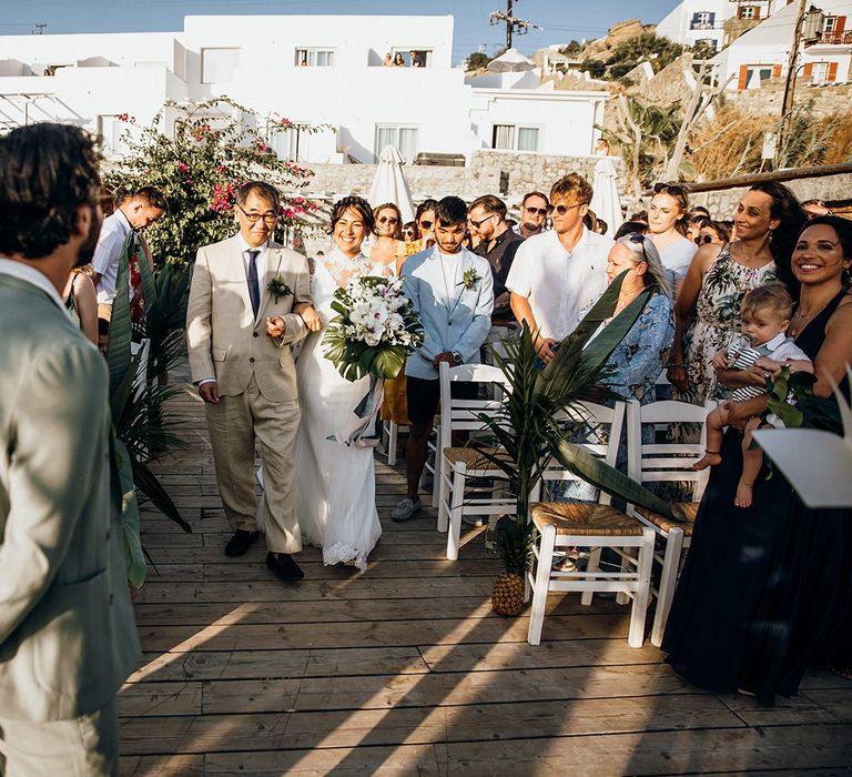 Bride walks down the aisle to meet groom