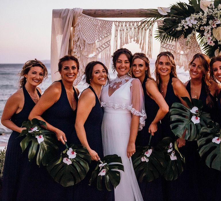 Navy blue bridesmaid dresses with palm leaf bouquet