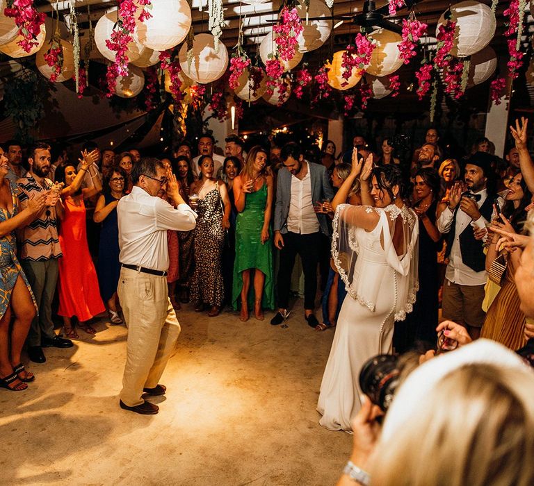 Bride and groom first dance under lanterns and flowers