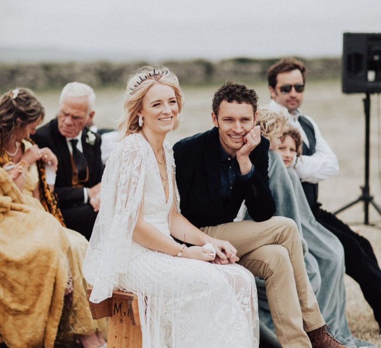 Boho Bride in Lace Rue de Seine Wedding Dress and Crown and Groom in Blazer Smiling During the Wedding Readings