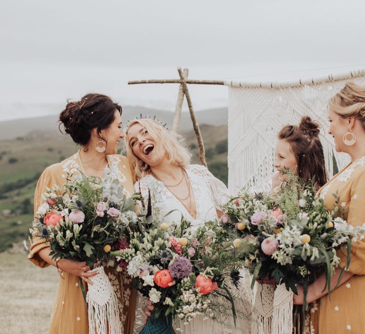 Bridal Party Holding Wildflower Bouquets Laughing Together