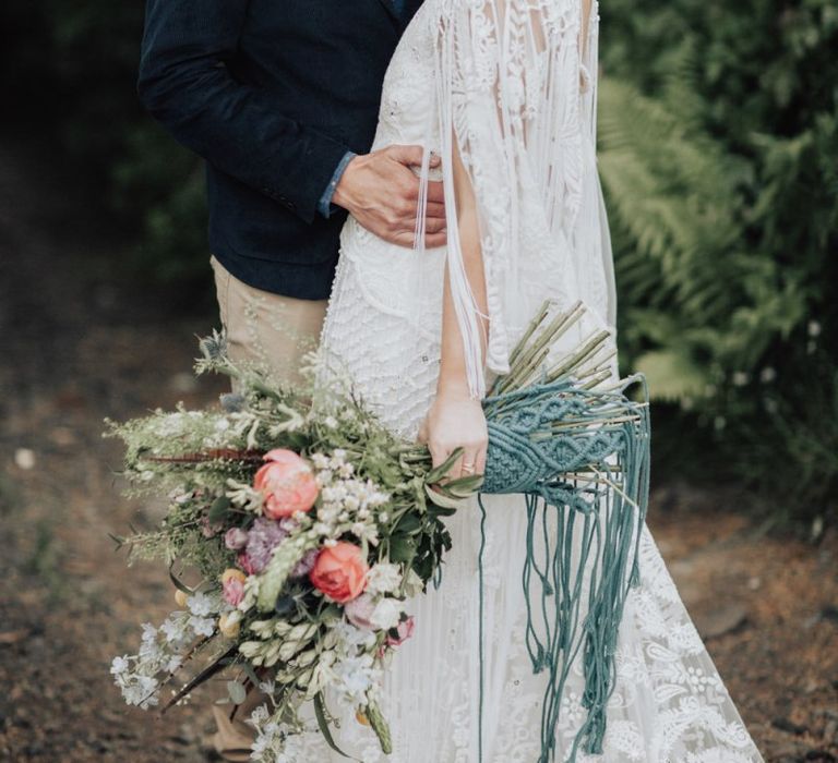 Groom in Chinos and Navy Blazer Holding His Wife in a Lace Wedding Dress