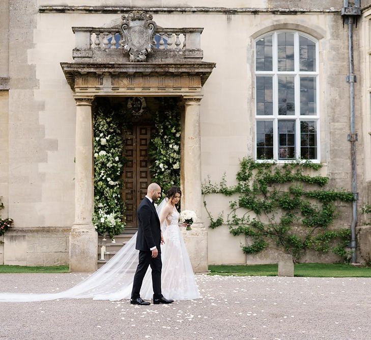 Bride and GRoom in Classic Black Tie Attire Walking In Front Of Elmore Court Wedding Venue