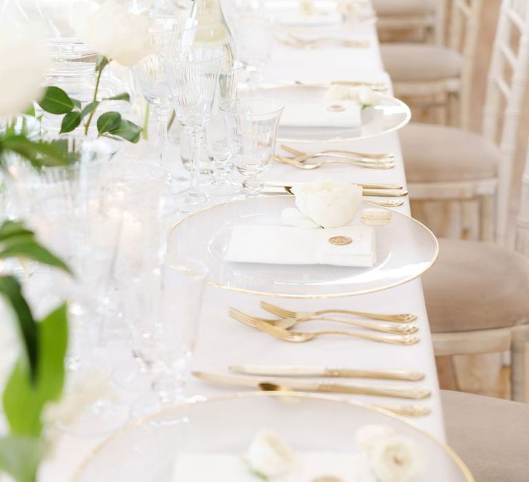 Elegant Place Setting with Glass Gold Rimmed Charger Plates and Gold Cutlery