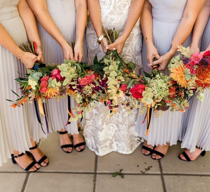 Colourful wedding bouquets and bride in Grace Loves Lace wedding dress