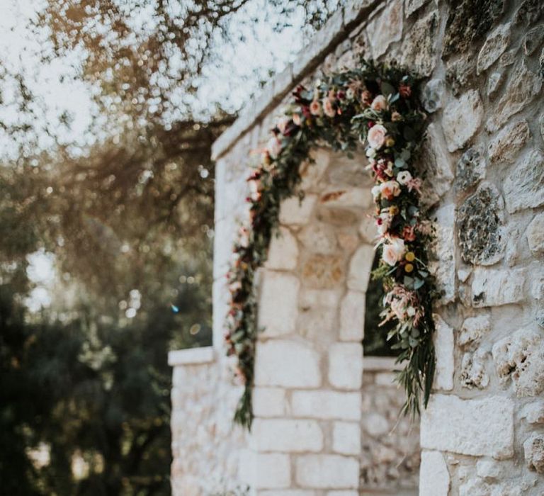 Pink wedding flower arch at ceremony venue