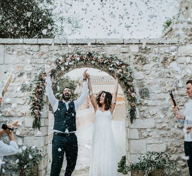 Confetti exit for bride in Max Mara wedding dress and groom