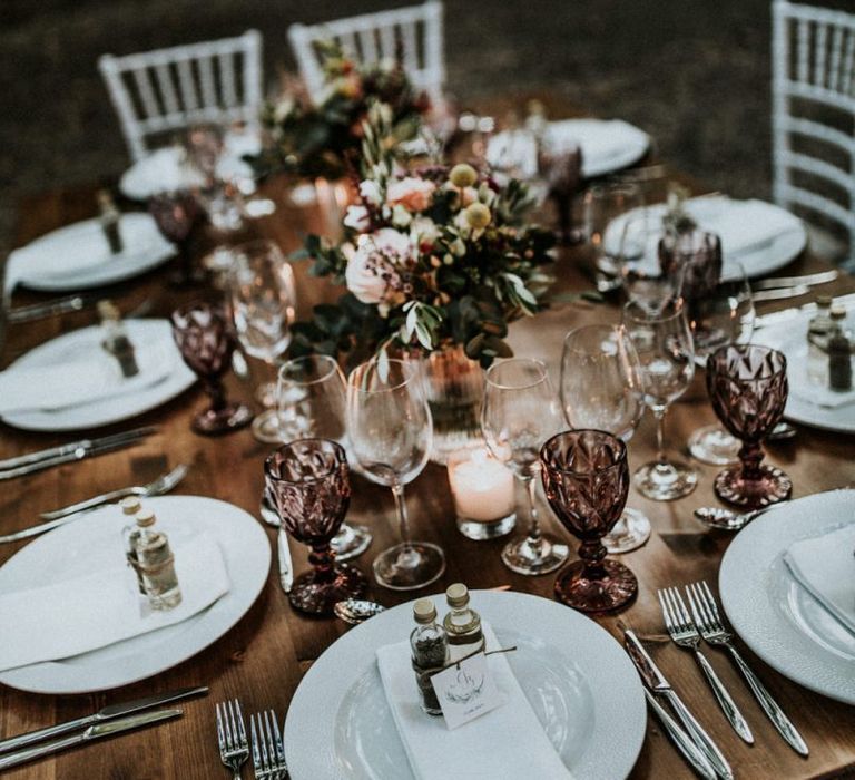 Wedding table decor with flowers and purple glassware