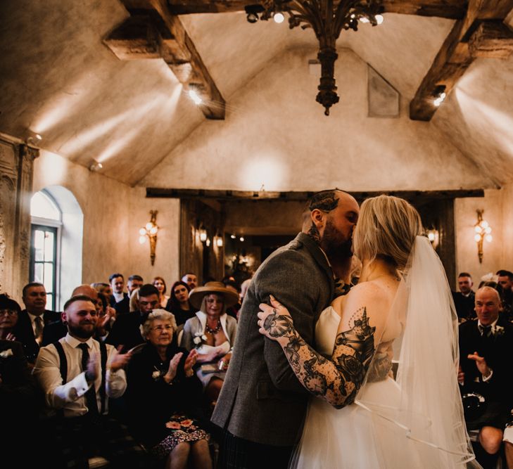 Wedding Ceremony with Bride in Essense of Australia Wedding Dress Kissing the Groom in a Tartan Kilt