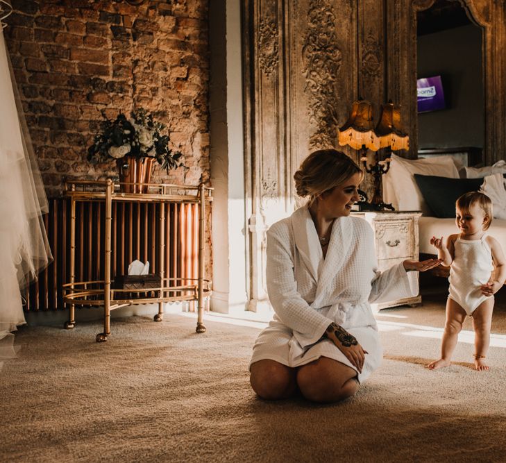 Wedding Morning Bridal Preparations with Bride in Getting Ready Robe Kneeling Down Playing With Her Daughter