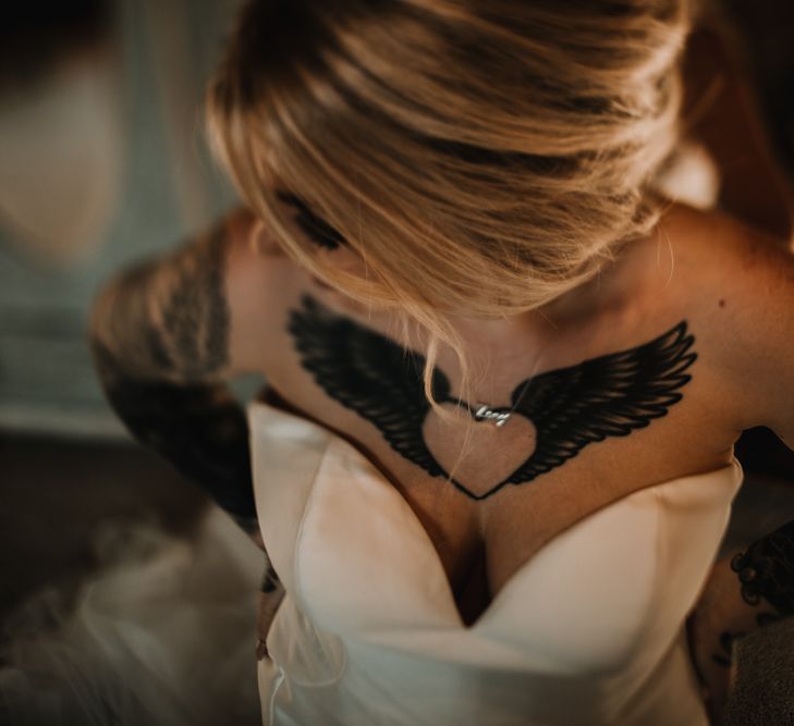 Tattooed Bride in Sweetheart Neckline Wedding Dress Showing Off Her Heart and Wings Ink