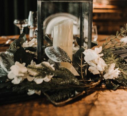 Lantern Centrepiece Surrounded by White and Green Wedding Flowers