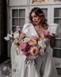 Bride holding a colourful pink and white rose wedding bouquets 