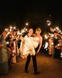 Groom lifting his bride in the air during their sparkler send off 
