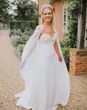 Bride in a handmade wedding dress, bridal cape and crown.