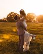 bride is lifted up by the groom for their golden hour wedding photos