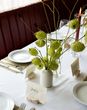 White bud vases with green florals and blooms with place names
