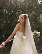 Bride in princess wedding dress with veil and white flower bouquet