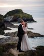 bride wearing a sparkly bespoke wedding dress by the sea on wedding day with groom