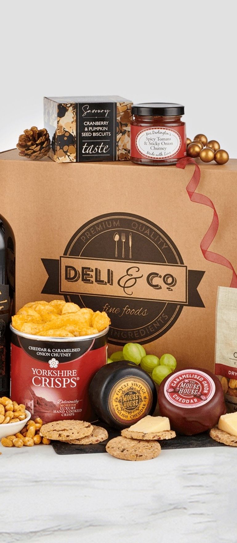 Luxury wedding gift hamper with red wine, cheese, savoury biscuits, crisps, nuts, and gourmet treats presented in a Deli & Co gift box